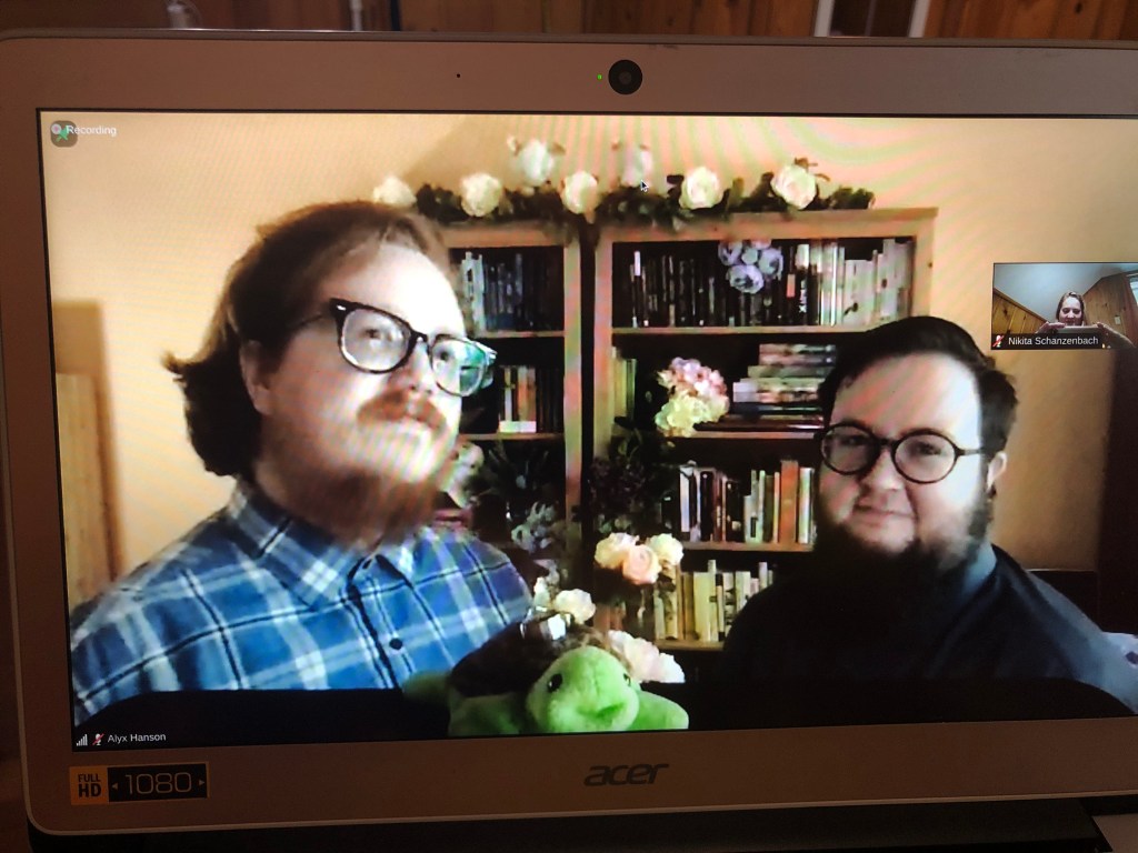 The soon-to-be husbands look at the computer camera; a Beanie Baby turtle (Prime Minister Winston Turthill) smiles and holds their rings on his back.